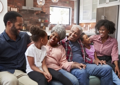 Multi-Generational Family Smiling and Laughing on Couch