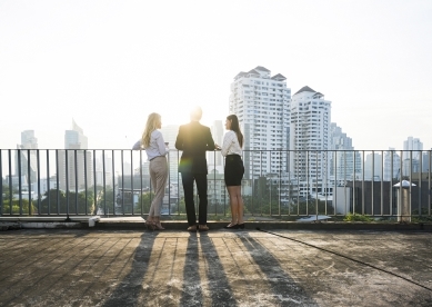 Three People Looking Towards City