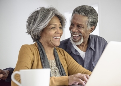 Senior Couple Laughing by Laptop