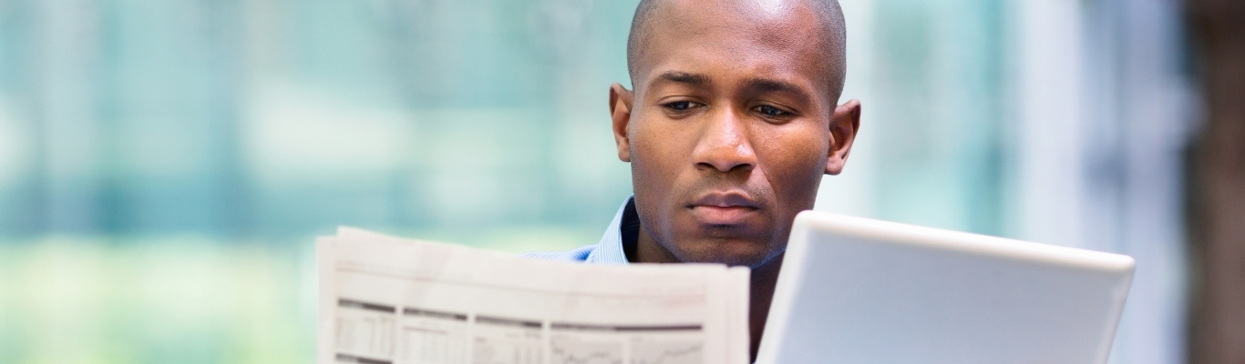 Black man looking at newspaper