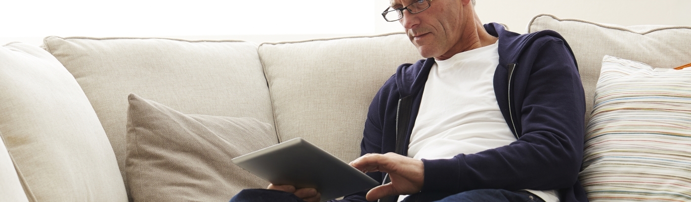 Man on Couch Looking at iPad