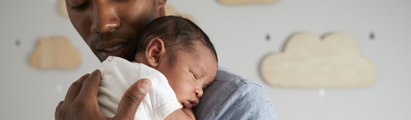 Young Father with Newborn Baby in Arms