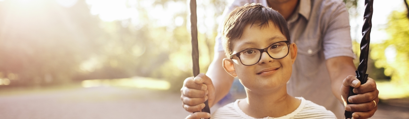 Boy being pushed on swing by father